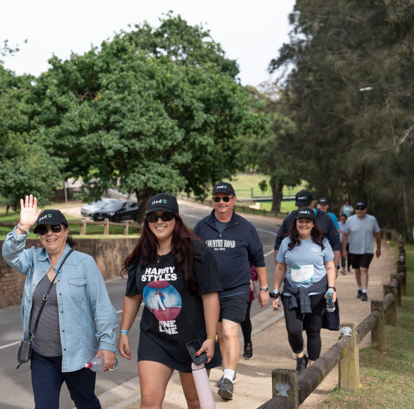 People participating in the ITSD MyWay event, walking and wearing branded hats.